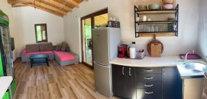 a kitchen with a refrigerator and a room with a couch at Guest house SARA in Čapljina