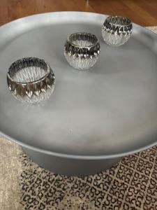 three empty glass bowls sitting on top of a table at Apartman Rentals Lux KG 2 in Kragujevac +27 photos