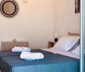 a bedroom with a bed with two towels on it at κατοικιά PAROS in Drios