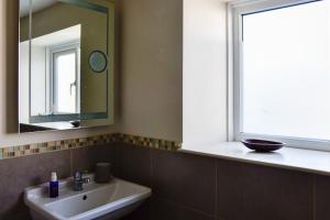 a bathroom with a sink and a mirror and a window at Cosy cottage in Bridport centre in Bridport +64 photos