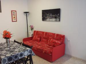 ベナルマデナにあるBonito apartamento con barbacoaのリビングルーム(赤いソファ、テーブル付)