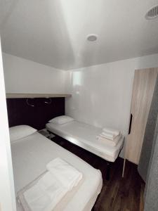 two beds in a small room with white walls at Dream Escape Mobile Home in Vodice +18 photos