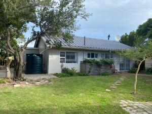 una casa bianca con un garage e un albero di Sandpiper Cottage a Kleinemonde