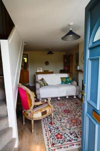 a living room with a couch and a chair at Cosy cottage in Bridport centre in Bridport