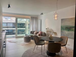 a living room with a table and chairs at Orfeo Knokke in Knokke-Heist