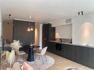 a kitchen and dining room with a table and chairs at Orfeo Knokke in Knokke-Heist +12 photos