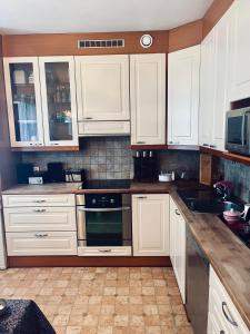 a kitchen with white cabinets and a stove top oven at Spacious Two Room Apartment in Espoo in Espoo