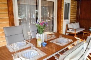 a wooden table with a vase of flowers on it at Dream Escape Mobile Home in Vodice