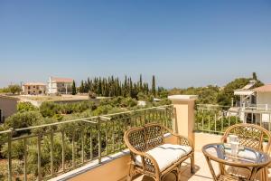 a balcony with two chairs and a table with a view at G&S Family Resort in Argostoli