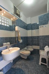 a bathroom with a sink and a toilet and a tub and a sink at Hotel Rosalia in Bordighera