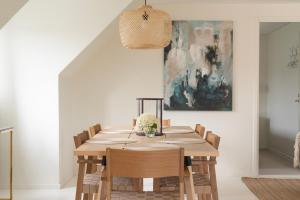 マルメにあるFalsterbo - Sea Breeze Apartmentのダイニングテーブル(椅子付)が備わります。壁には絵画が飾られています。 +22枚の写真