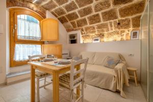 eine Küche und ein Esszimmer mit Tisch und Sofa in der Unterkunft Deliloft in Alghero