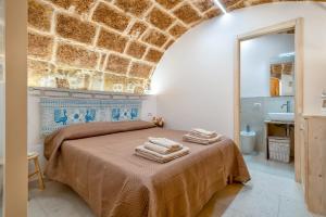 ein Schlafzimmer mit einem Bett, auf dem Handtücher liegen in der Unterkunft Deliloft in Alghero