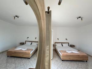 two beds in a room with a mirror at Aktea Apartments II in Kefalos