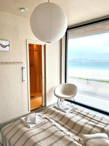 a bedroom with a bed and a large window at Exclusive Beach House Ramberg - Your Private Oasis in Ramberg