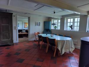 a kitchen and dining room with a table and chairs at Ferielejlighed på Svensmarkegaard in Stege