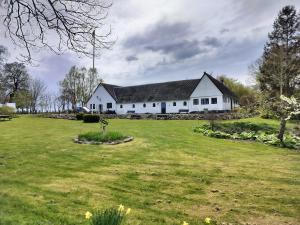 a large white house with a large grass yard at Ferielejlighed på Svensmarkegaard in Stege