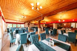 a dining room with tables and chairs and wooden ceilings at Resort EuroPark Fundata in Fundata