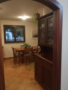 a dining room with a table and a entertainment center at Vila Magnolia in Vilanija