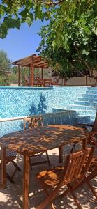 a wooden table and chairs sitting next to a pool at Vila Magnolia in Vilanija