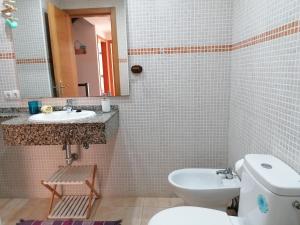 a bathroom with a toilet and a sink and a mirror at Casa en Cotillo Lagos with Wifi & Netflix in Cotillo +39 photos