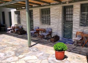 an outdoor patio with tables and chairs and a table at Thalassa3 in Andros