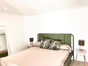 a bed with a green headboard in a bedroom at Casa rural Can Joaquinet Rossell in Rosell