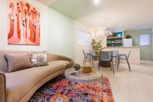a living room with a couch and a table at オープンセール 2棟貸切 最大20名ビーチまで車で4分 駐車場4台 tla&tdy ツインズロッジA棟B棟貸切 in Yomitan +86 photos