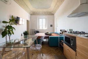 a kitchen with a glass table and a living room at La Camera Verde in Pisa
