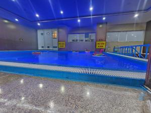 a large swimming pool with blue water in a building at Khách sạn sơn thinh 23d Thuỳ Vân in Vung Tau
