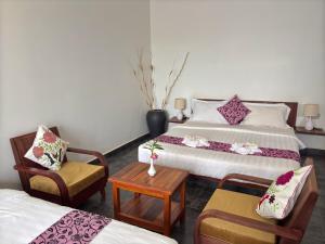 a hotel room with two beds and a table and chairs at Sam So Boutique Villa in Siem Reap