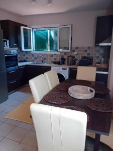 a kitchen with a wooden table and white chairs at Sunday Villa in Agios Georgios