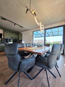 a dining room with a wooden table and chairs at Vila Bio Green in Chinteni