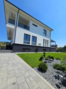 a large white house with a yard at Vila Bio Green in Chinteni