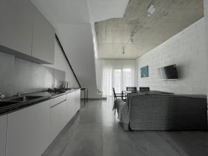 a kitchen with white cabinets and a table in it at Cottages - Townhouses in Ureki