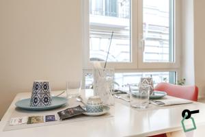 a white table with plates and glasses on it at Residenza Scarlatti Napoli in Naples +29 photos