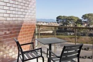 two chairs and a table on a balcony with a view at Moxy La Ciotat in La Ciotat
