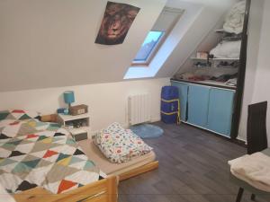 a attic bedroom with a bed and a kitchen at Villa individuelle 5 mn Lille centre Chr/eurasante in Haubourdin