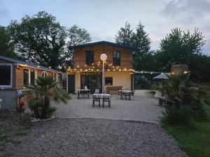 dom z patio ze stołami i krzesłami w obiekcie Clos Des Monts w mieście Saint-Martin-des-Besaces