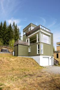 a green house on top of a hill at En perle på Gjøvik, nær populær strand ved Mjøsa in Gjøvik