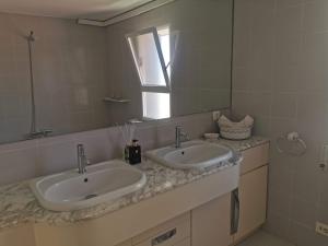 ein Badezimmer mit zwei Waschbecken und einem Spiegel in der Unterkunft APARTAMENTO SOL Y MAR Primera Linea in Playa de Gandia + 21 Fotos