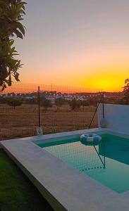 a swimming pool with a sunset in the background at Tribo da Praia in São Luis