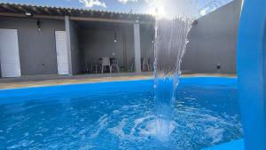 a water fountain in the middle of a swimming pool at Pousada Aconchego in Juazeiro do Norte