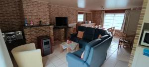 a living room with a blue couch and a fireplace at Duinzicht in Koksijde