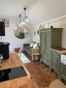 a living room with a green cabinet and a couch at 1 mile from Harry Potter Tour Self Contained Flat One bedroom plus new sofa bed in lounge in Abbots Langley