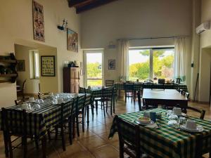 een eetkamer met tafels en stoelen en een groot raam bij Agriturismo Silis in Sennori