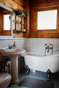 un bagno con vasca e lavandino di Winnica Nad Źródłem - Domki w winnicy z kominkami i tężniami a Sierzawy Altre 79 foto