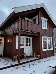 a wooden house with a balcony and a porch at Hytte i Målselv Fjellandsby in Bergset