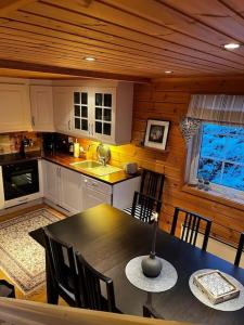 a kitchen with a table and chairs in a room at Hytte i Målselv Fjellandsby in Bergset