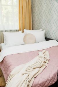 un letto con una coperta rosa e bianca sopra di 2 кімнатні квартири на Каштановій Алеї. Мережа AlexApartments. Безконтатне заселення 24/7 a Poltava